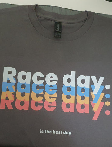 Gray t-shirt with 'Race day' text in colorful letters on a white surface.