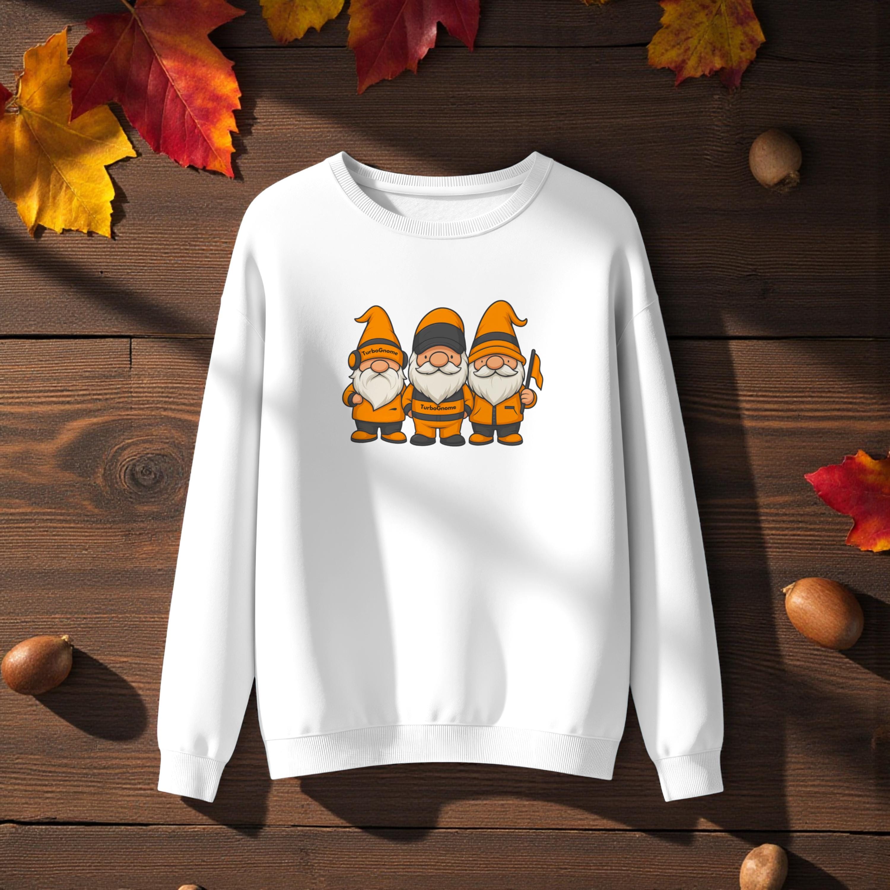 White sweatshirt with cartoon gnomes on a wooden surface with autumn leaves and acorns.