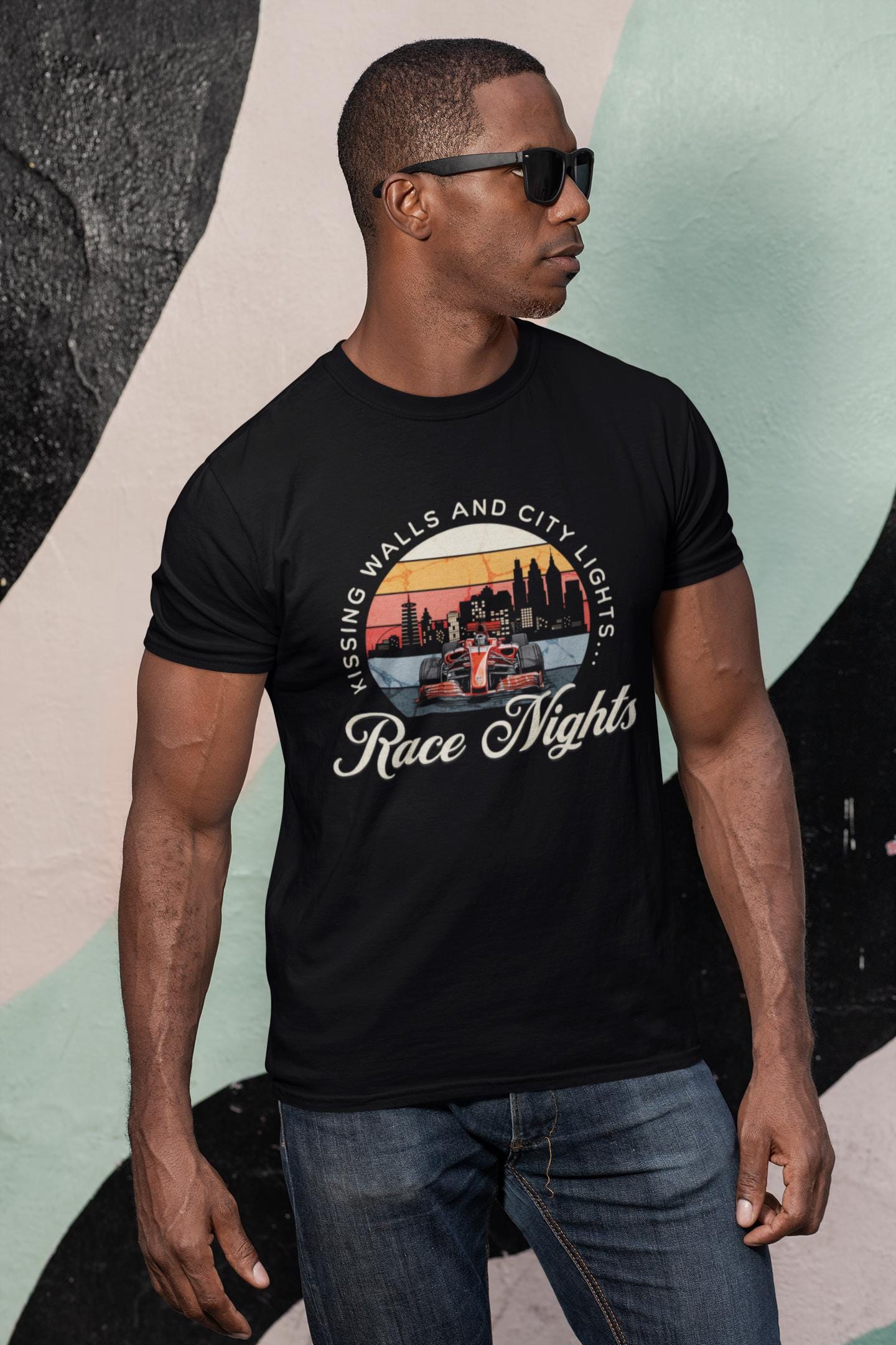 Man wearing a black t-shirt with a graphic design and text, standing against a colorful abstract background.