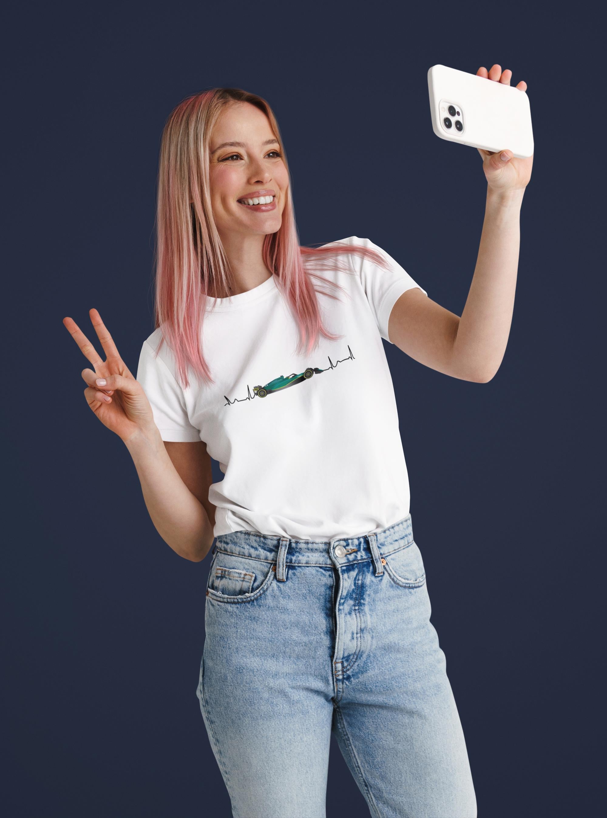 Woman taking a selfie with a phone, wearing a white t-shirt and blue jeans on a dark background