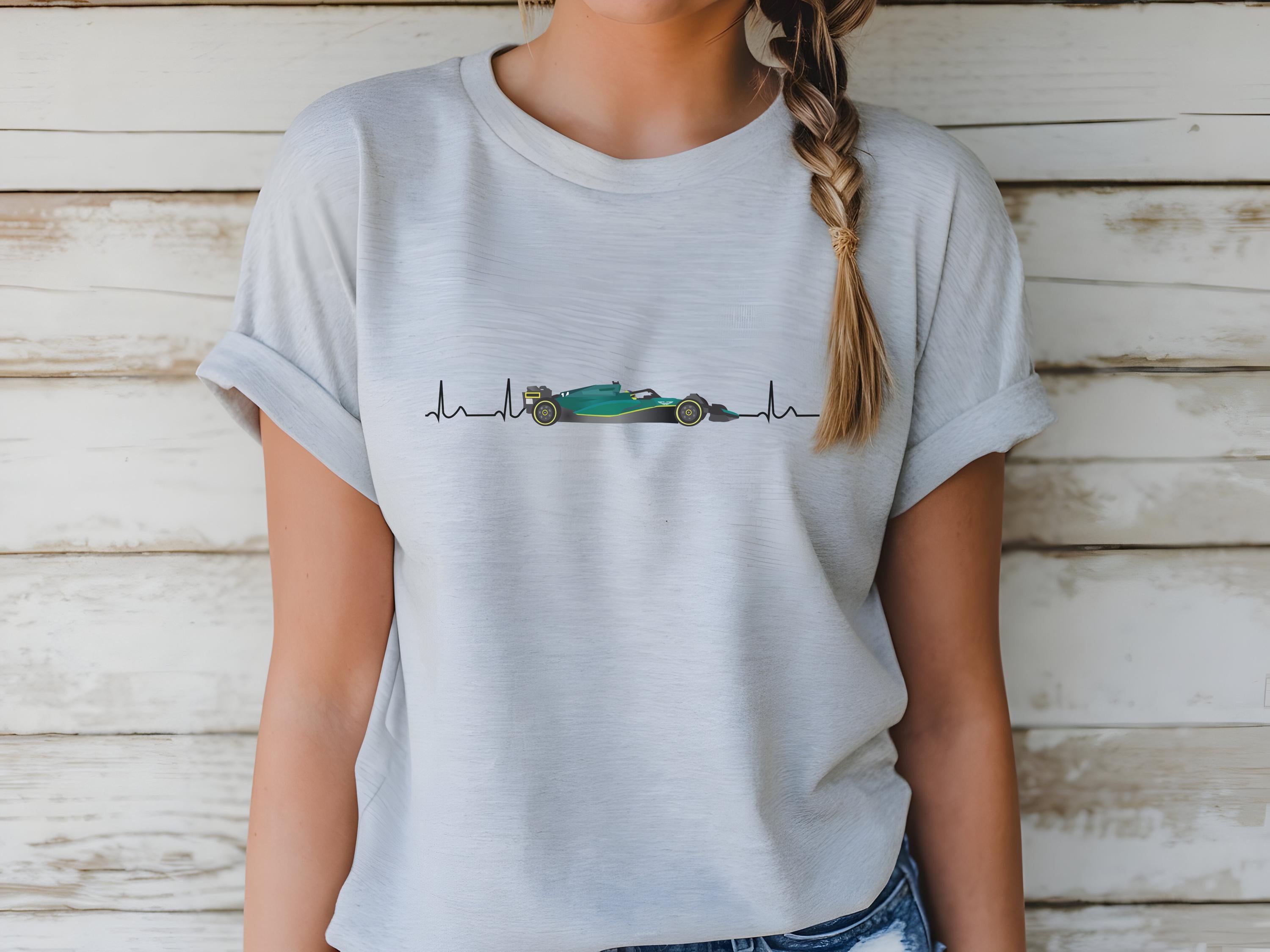 Person wearing a light gray t-shirt with a graphic design on a wooden background