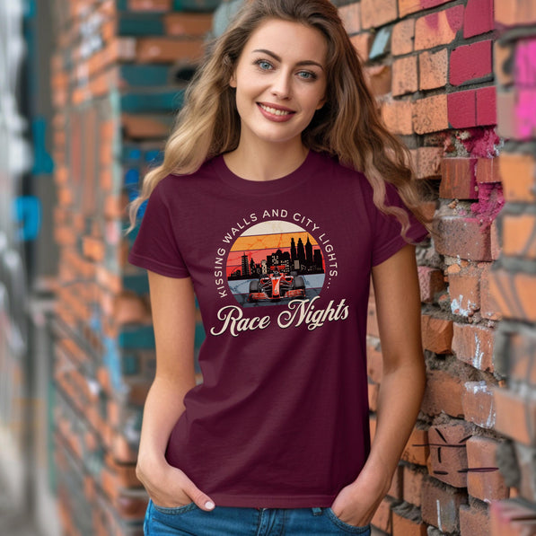 Woman wearing a maroon t-shirt with a graphic design and text, standing against a brick wall.