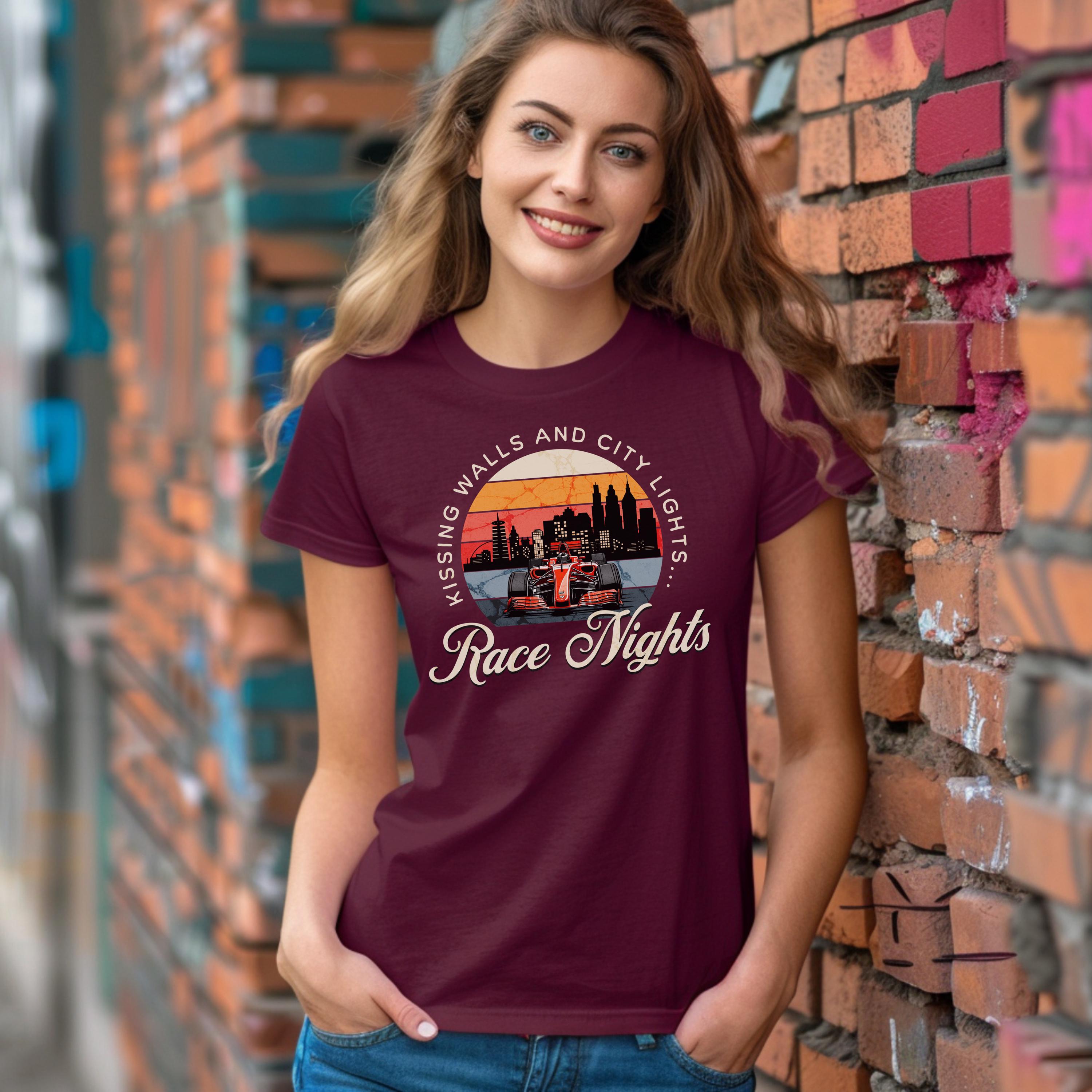 Woman wearing a maroon t-shirt with a graphic design and text, standing against a brick wall.