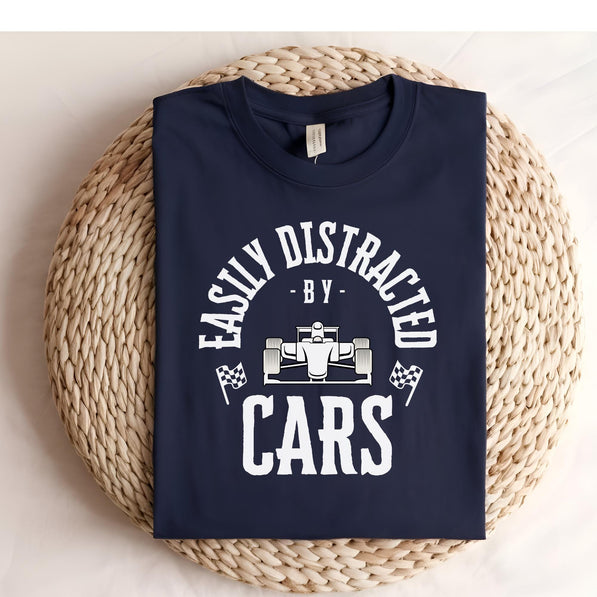 A navy blue t-shirt with white text that reads 'Easily Distracted - By - Cars' with a white race car graphic in the center.