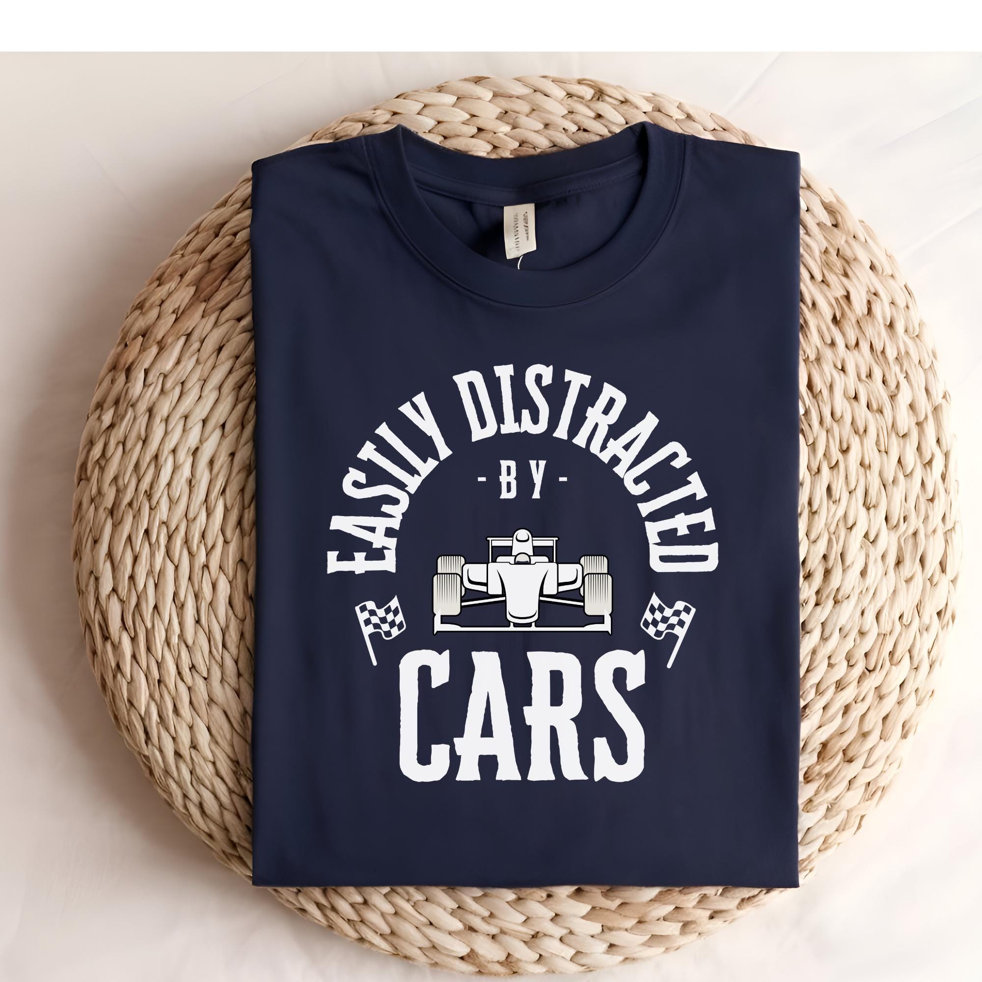 A navy blue t-shirt with white text that reads 'Easily Distracted - By - Cars' with a white race car graphic in the center.